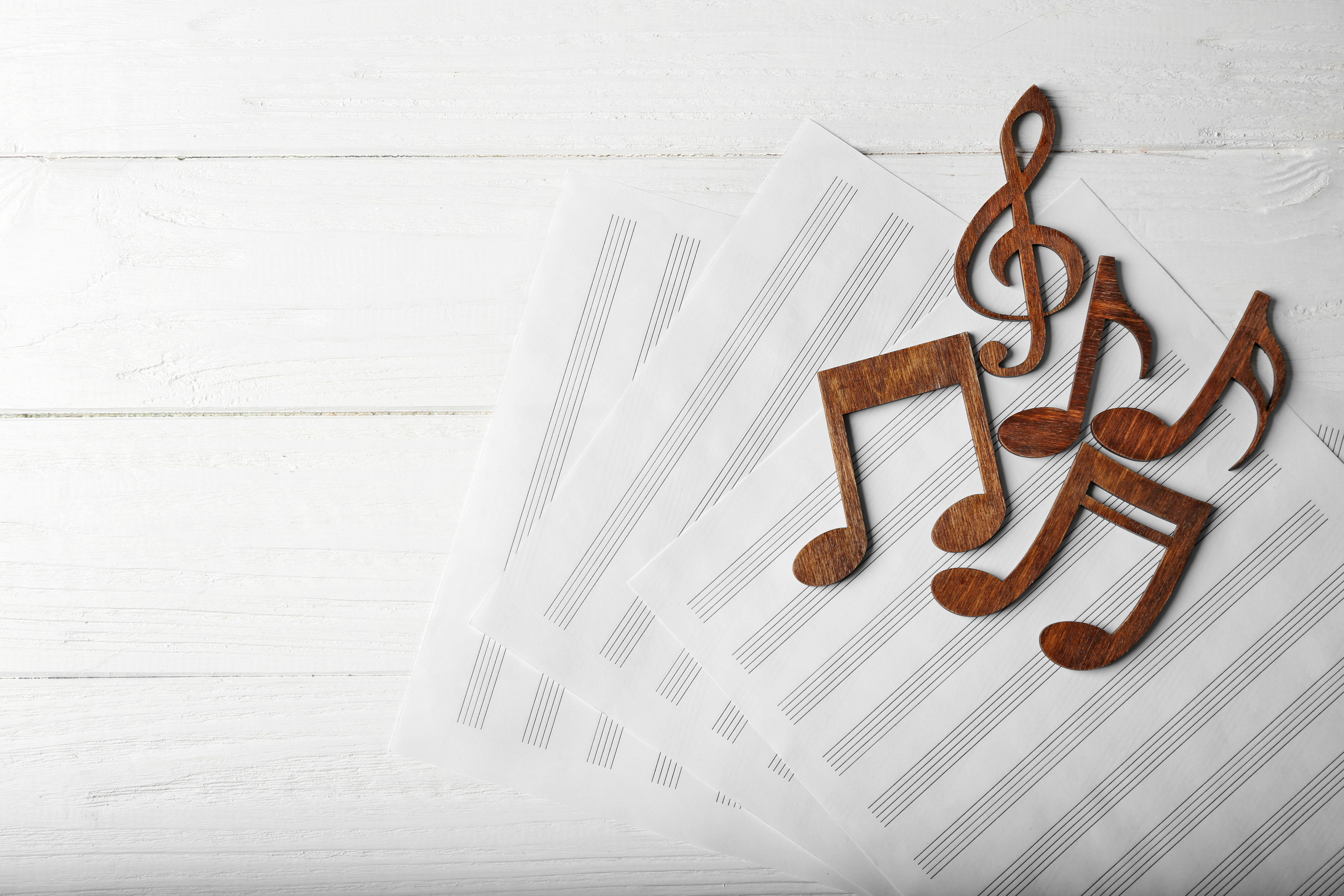 Musical Notes Lying on Music Sheets on Wooden Background